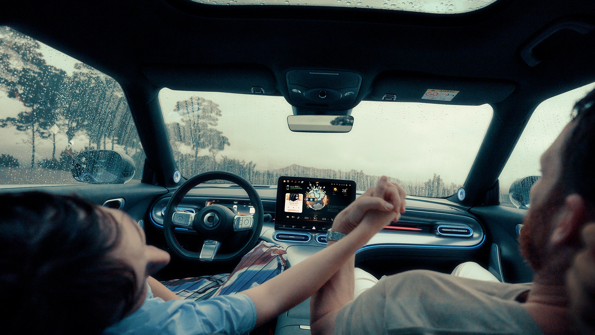 smart #1 auton kojelauta ja kuljettajan ja matkustajan kädet yhdessä.