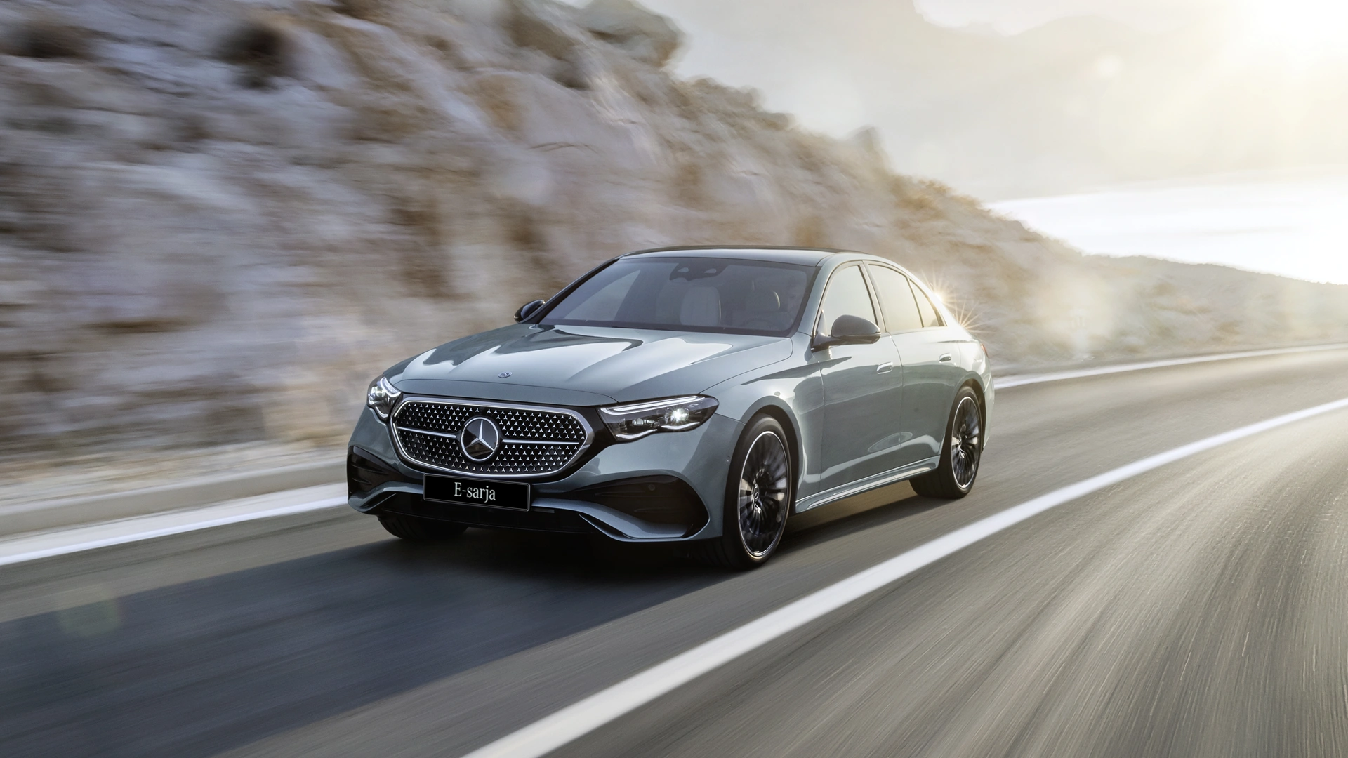 Mercedes-Benz E-sarjan sedan tiellä etuviistosta kuvattuna.
