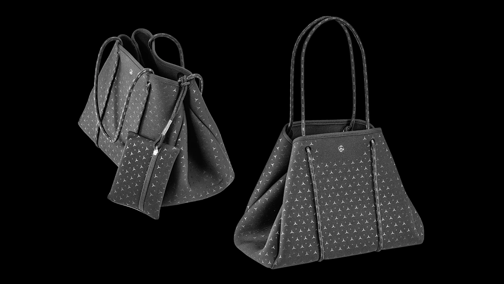 Mercedes-Benz Collection-shopperkassit mustalla taustalla. Toinen kuvattuna sivusta ja toinen viistosta, jossa käytännöllinen kosmetiikkapussi laukun ulkopuolella.
