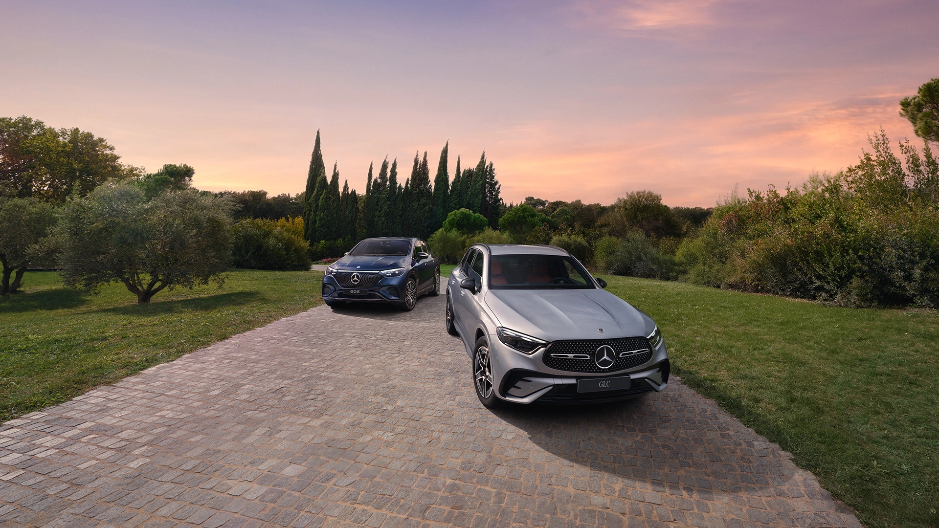 Mercedes-Benz EQE ja GLC auringonlaskumaisemassa