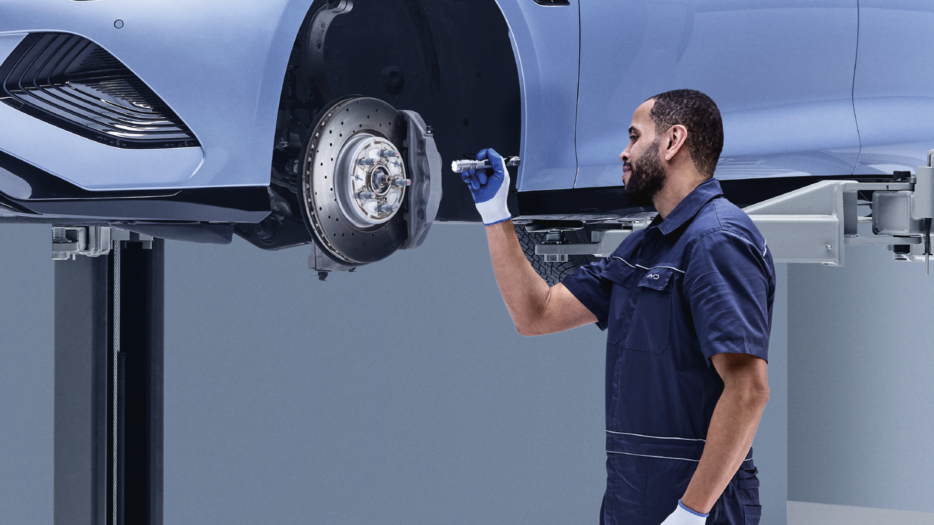 BYD-mekaanikko tarkastamassa BYD Seal-auton jarrujen kuntoa.